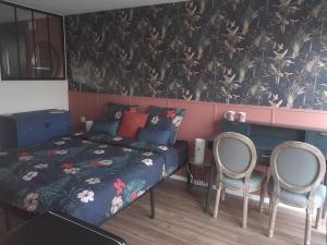a bedroom with a bed and two chairs at Suite des Grands Crus in Beaune