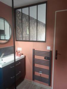 een badkamer met een wastafel en een spiegel bij Suite des Grands Crus in Beaune