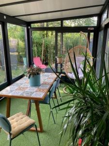 een patio met een tafel en stoelen en een potplant bij Suite des Grands Crus in Beaune