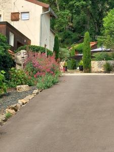 a garden with a statue of a head next to a house at Les Allumettes d'Ecorsaint in Écorsain +45 photos