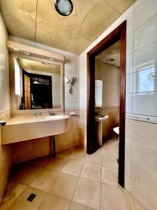 bagno con lavandino e specchio di Dream Palace Hotel ad Ajman