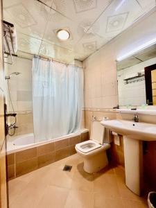 a bathroom with a toilet and a sink and a shower at Dream Palace Hotel in Ajman 