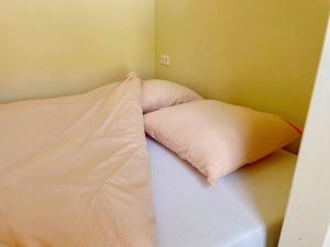 un letto con due cuscini sopra in una stanza di Uniek vakantieverblijf Den Burg a Den Burg