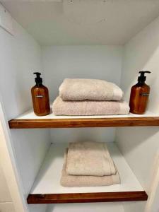 due asciugamani e due bottiglie su una mensola in bagno di Uniek vakantieverblijf Den Burg a Den Burg