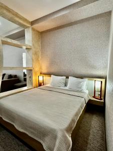 ein Schlafzimmer mit einem großen Bett mit weißen Kissen in der Unterkunft Liel in Tbilisi City