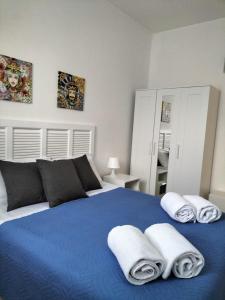 sypialnia z niebieskim łóżkiem i ręcznikami w obiekcie Endless Summer w mieście Fontane Bianche