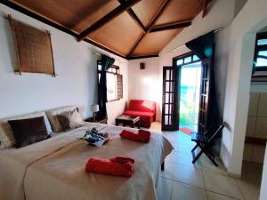 a bedroom with a large bed with red pillows on it at Bangalô Panorâmica in Conde