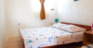 a bedroom with a bed with a comforter on it at Apartments Stefan Cesarica in Cesarica