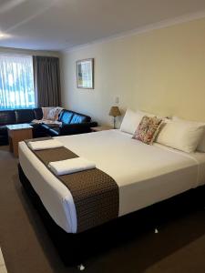 a bedroom with a large bed and a living room at Emu Point Motel in Albany