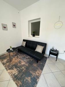 czarna kanapa w salonie z dywanem w obiekcie Apartment 960 w Koprze
