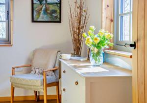 a vase of flowers sitting on a desk with a chair at Patagonia in Builth Road