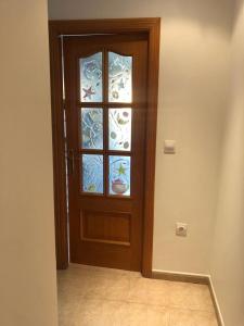 a wooden door with a glass window in a room at Como en casa 1 in Elche