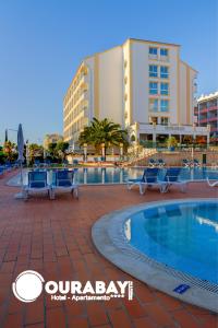 a resort with a swimming pool in front of a building at Ourabay Hotel Apartamento - Art & Holidays in Albufeira