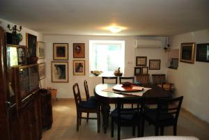jadalnia ze stołem i krzesłami oraz oknem w obiekcie Rustic Holiday Home Miketa w mieście Lukoran