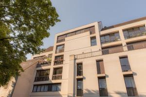 ein Apartmenthaus mit Fenstern und Balkonen in der Unterkunft Suite Montrachet 4 personnes vue cathédrale 1 Place de parking in Dijon
