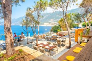 un patio con tavoli e sedie accanto all'acqua di Mavilim Hotel a Kaş