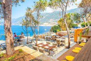 a patio with tables and chairs next to the water at Mavilim Hotel in Kaş