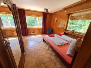 a bedroom with a bed in a room with windows at Ferienwohnungen-Allerheiligen-Wasserfälle in Oppenau