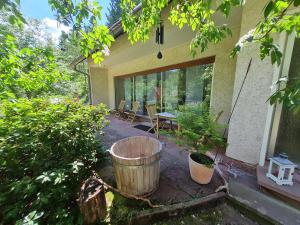 eine Terrasse mit einem Fass, einem Tisch und Stühlen in der Unterkunft Ferienwohnungen-Allerheiligen-Wasserfälle in Oppenau