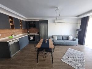 uma cozinha e sala de estar com uma mesa e um sofá em Gray House Kusadasi em Ağaçlı