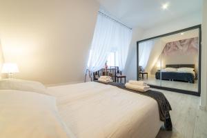 una camera da letto con un grande letto bianco e uno specchio di Okno na Ratusz De Luxe a Mrągowo