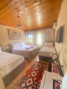 a bedroom with two beds and a wooden ceiling at Marko's House in Gjirokastër