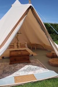a canvas tent with a wooden table inside at Rescorla Retreats- Poldark in Mevagissey