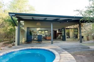 a house with a swimming pool and a patio at Veld Villa in Marloth Park