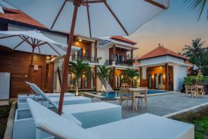 una casa con patio con sedie e ombrellone di Penida Paradiso a Klungkung