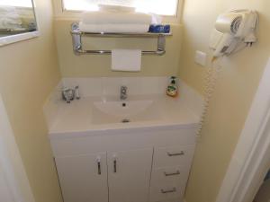 a bathroom with a sink and a phone at Emu Point Motel in Albany