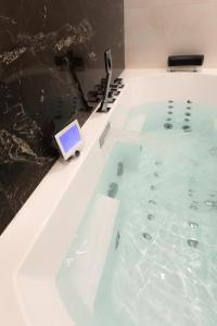 una bañera llena de agua con una tablet. en Suite Montrachet 4 personnes vue cathédrale 1 Place de parking, en Dijon