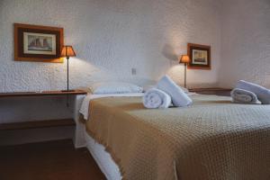 a hotel room with two beds with towels on them at Vagia Traditional, Aegina Island in Vaia