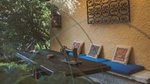 a picnic table with pillows on a wall at Vagia Traditional, Aegina Island in Vaia
