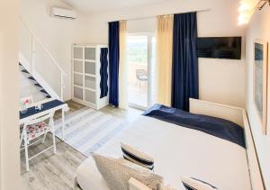 a bedroom with a bed and a desk and a balcony at Eleonora in Banjole
