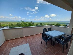 a patio with a table and chairs on a balcony at APARTMAN D&D , KRK-VRH in Vrh