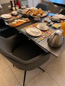 una mesa con platos y comida. en Le Loft Ancien Haras de la Tour en Lamothe-Landerron