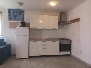 a kitchen with white cabinets and a stove top oven at APARTMAN D&D , KRK-VRH in Vrh +1 photo