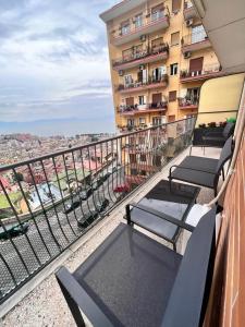 einen Balkon eines Gebäudes mit Tischen und Stühlen in der Unterkunft Oliver Luxury Home in Neapel