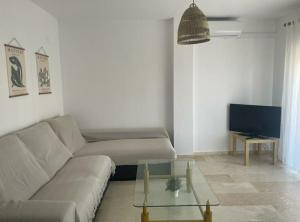een woonkamer met een bank en een tv bij Pisito del Sol in Algarrobo-Costa