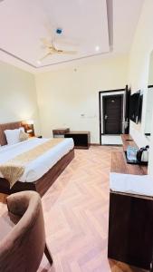ein großes Schlafzimmer mit einem Bett und einem Sofa in der Unterkunft HOTEL EKAS in Charbagh