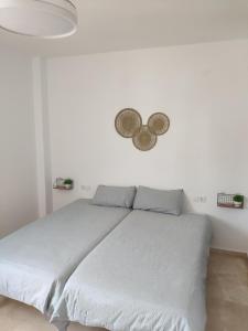 Ce lit se trouve dans une chambre blanche dotée d'un mur blanc. dans l'établissement Pisito del Sol, à Algarrobo-Costa