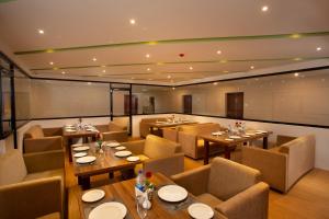 comedor con mesas y sillas en Hotel Keerthi en Thiruvananthapuram