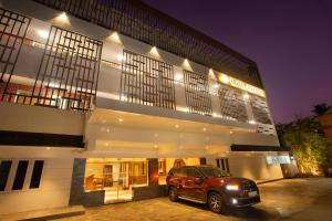 a car parked in front of a building at night at Hotel Keerthi in Trivandrum