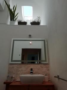 een wastafel in de badkamer met een grote spiegel erboven bij Frina di Mari b&b in San Teodoro