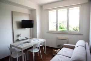 een woonkamer met een witte bank en een tafel bij CasaLO' Igea in Bellaria-Igea Marina