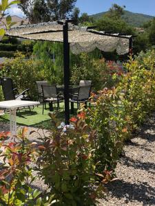 a garden with a table and chairs and an umbrella at Maxima Sunset in Sainte-Maxime