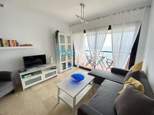 een woonkamer met een bank, een tv en een tafel bij El Salon, Nerja BLUEWATER VILLAS in Nerja