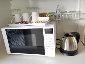 a microwave sitting on a counter with a tea kettle at Donald Riverside Motel in Donald