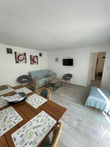 a dining room with a table and a living room at Maxima Sunset in Sainte-Maxime