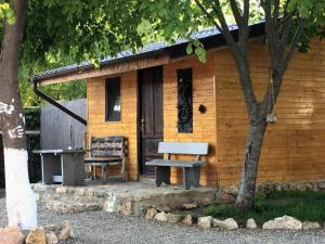 Cabaña de madera pequeña con banco y mesa en Magic Garden Bungalow, en Vama Veche